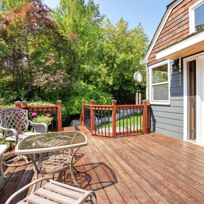House exterior with large open deck and outdoor furniture.