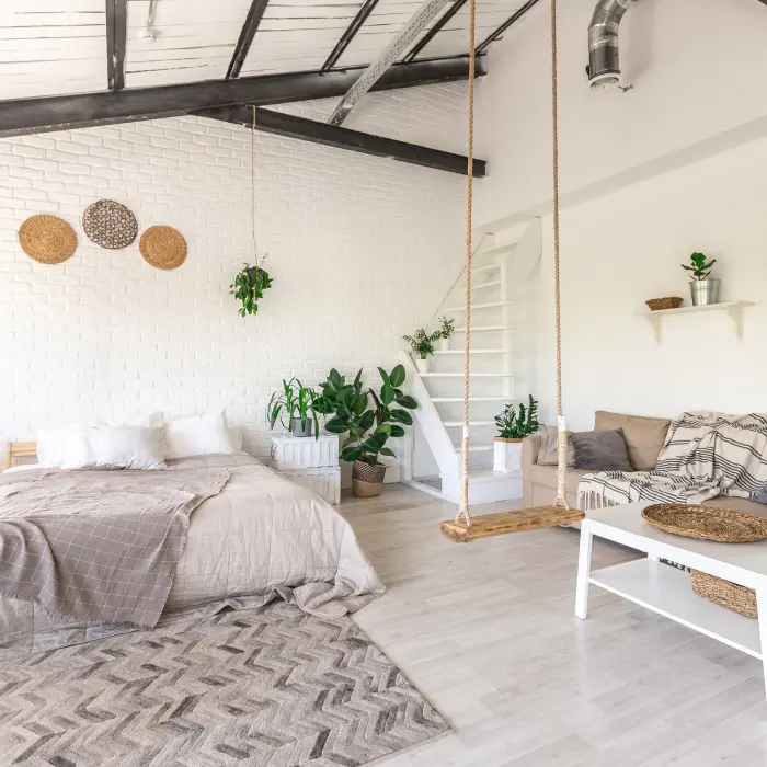 Luxury bedroom design in a rustic cottage in a minimalist style. white walls, panoramic windows, wooden elements of decoration on the ceiling, rope swings in the middle of a spacious room.
