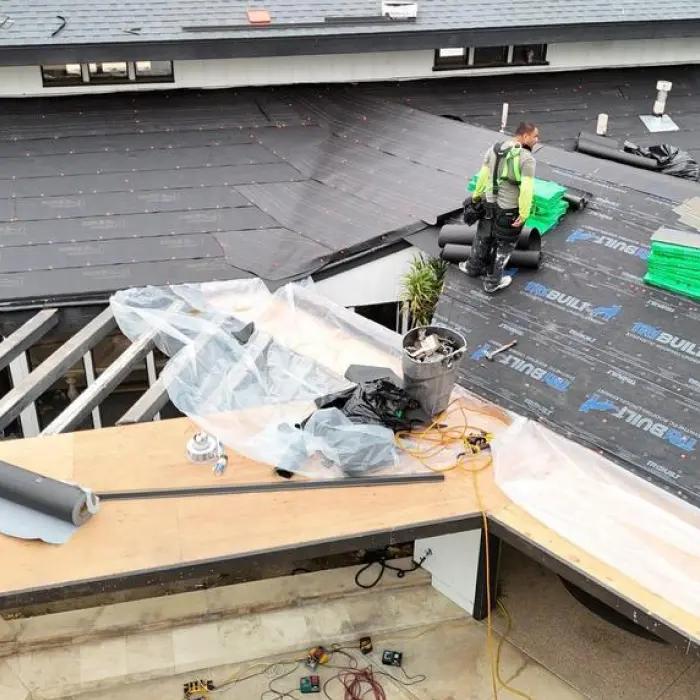 worker installing roofing underlayment